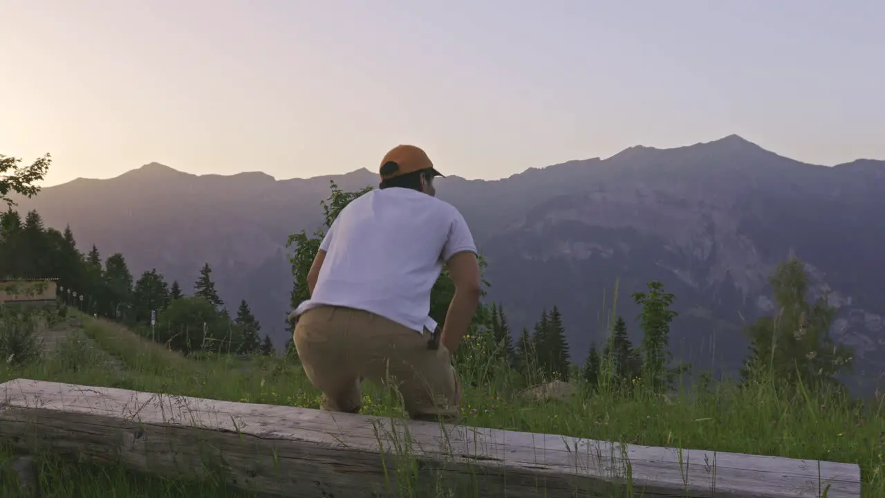 A Man Looking at the Alps Mountain View from The Edge of The Hill Back Side