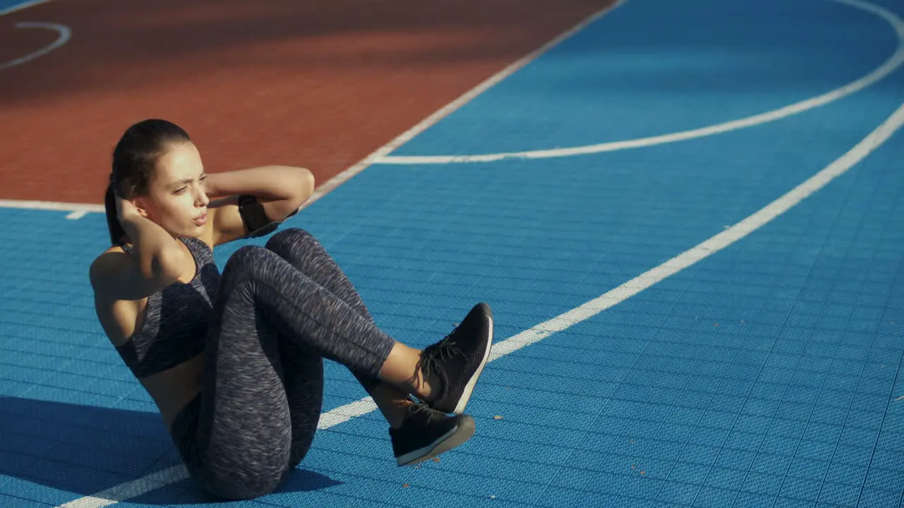 Sporty Woman Doing Abs At Outdoor Court On A Summer Day