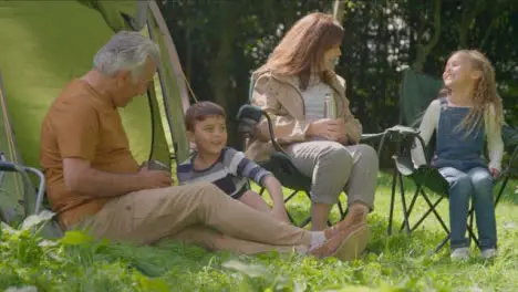 Low Angle Shot of Grandchildren Joining Their Grandparents by Their Tents