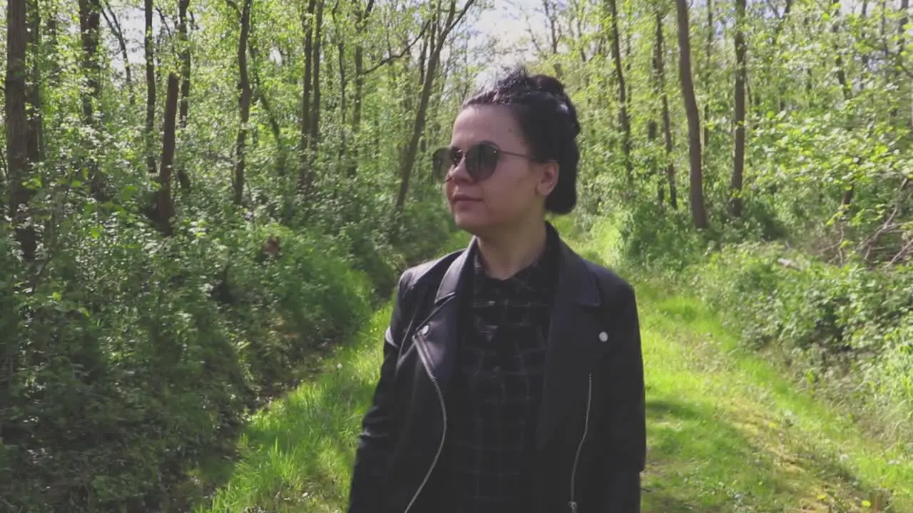 Girl walking through a narrow path in the forest