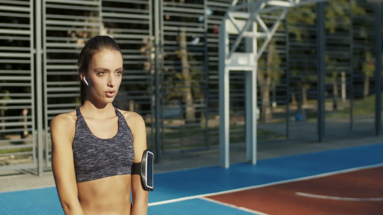 Fitness Girl With Airpods Doing Squats At Sport Court On Summer Morning