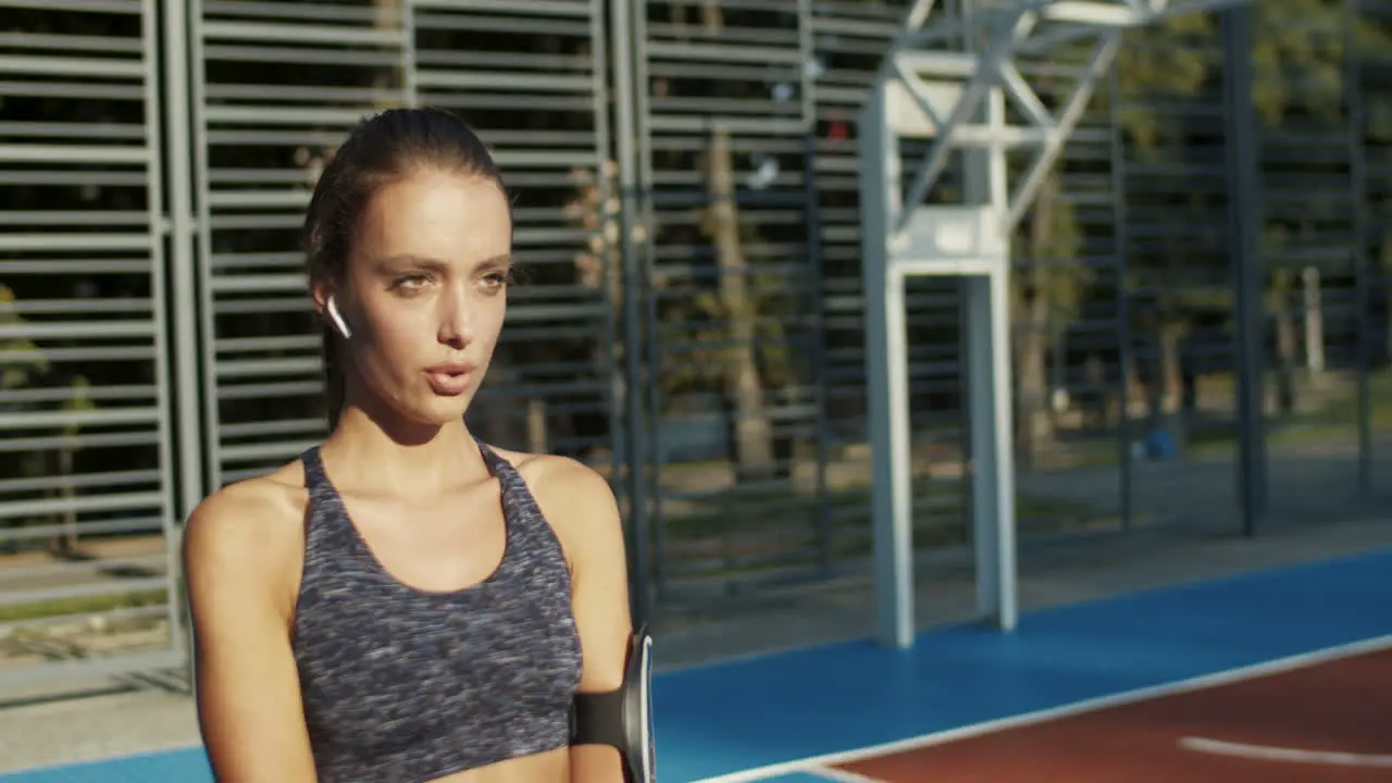 Fitness Girl With Airpods Doing Squats At Sport Court On Summer Morning 1