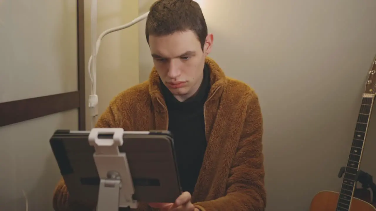 Caucasian Man Using Tablet In A Tablet Stand On The Table