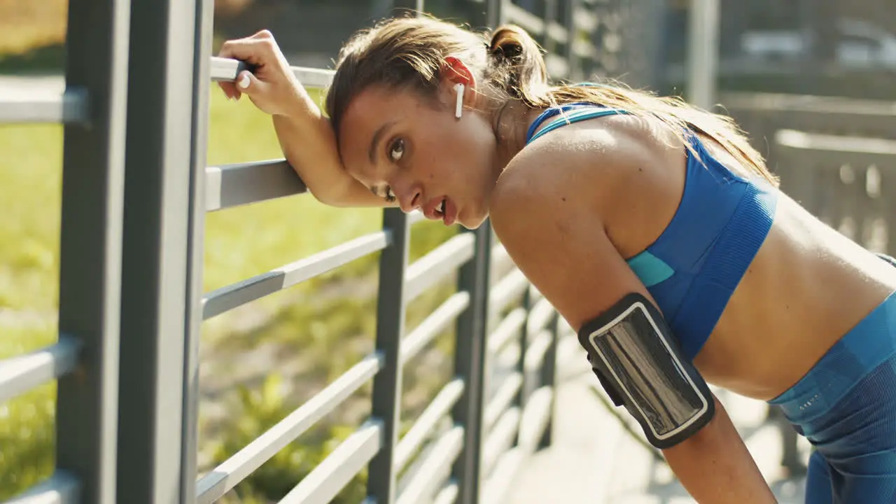 Side View Of A Tired Sportswoman With Airpods Resting And Breathing Hard After Workout At Outdoor Court On A Summer Day 1