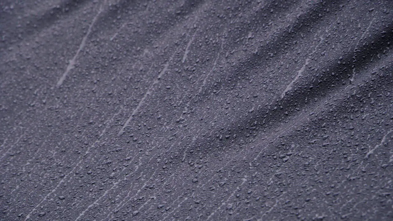 Heavy rain running down on black waterproof textile-1