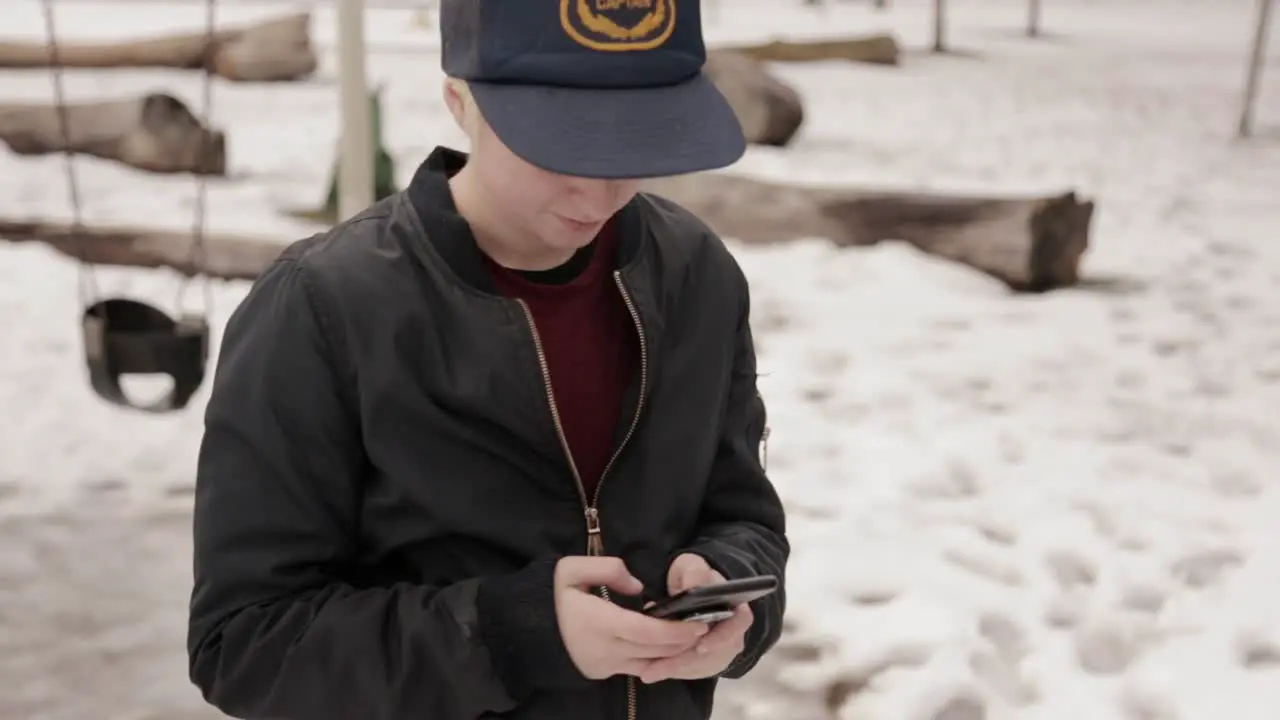 A person smiles as they text on their phone