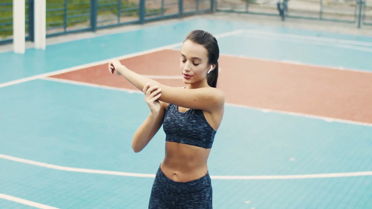 Sporty Girl Warming Up And Doing Stretching Exercises At Outdoor Court On A Summer Day