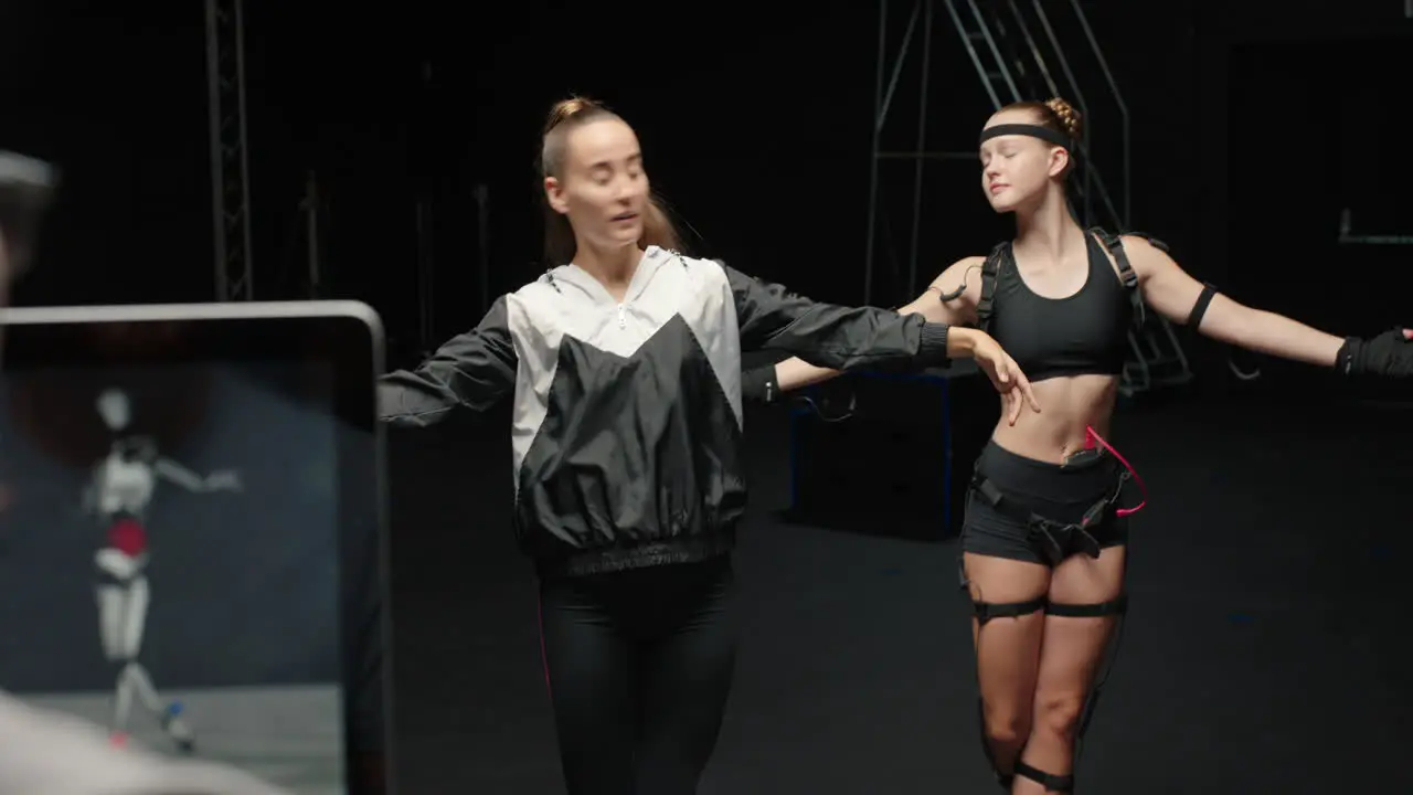 dancing woman wearing motion capture suit rehearsing ballet dance with instructor girl wearing mo-cap suit for 3d character animation for virtual reality technology