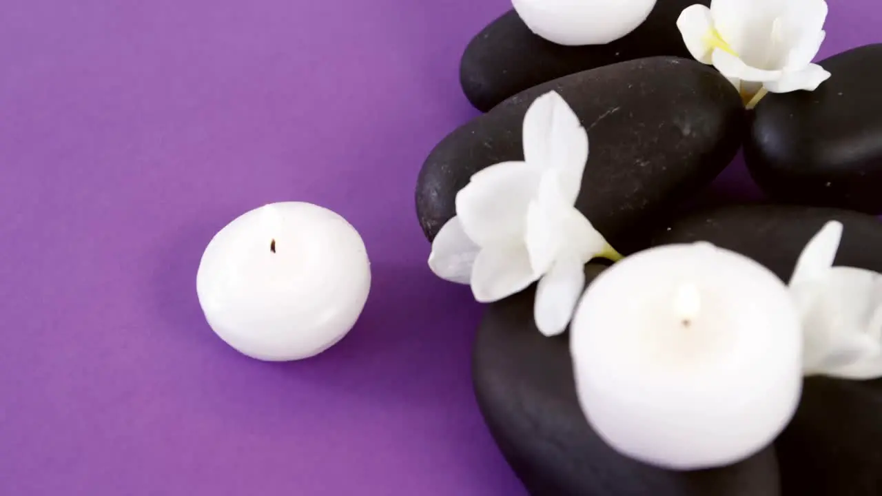 Close-up of pebble stones with flowers and candles