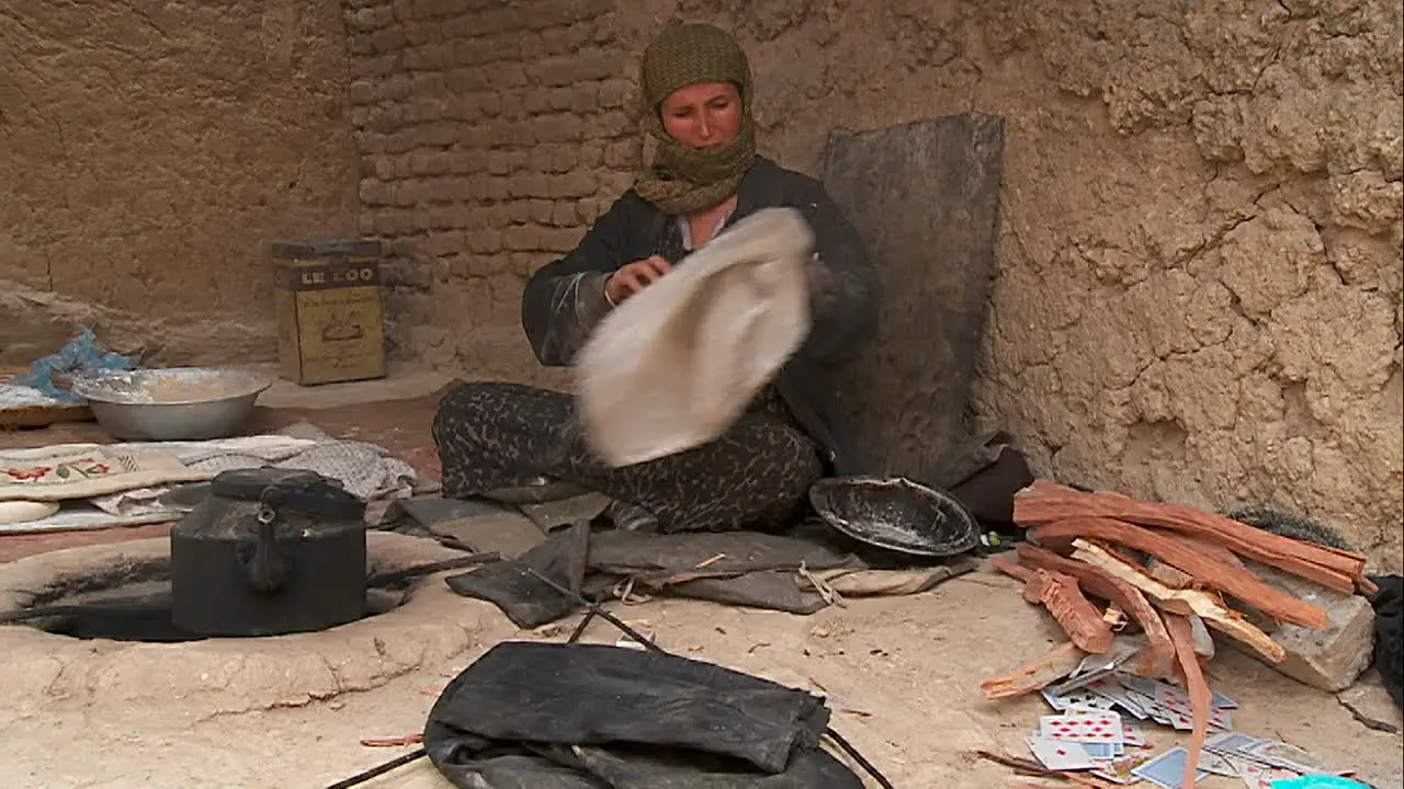 A woman puts wood into a tandor oven in Kabul Afghanistan