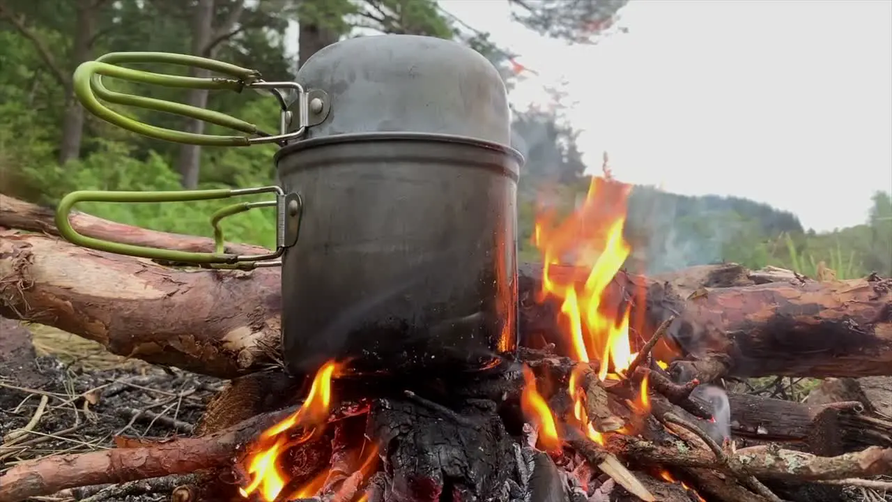 Cooking pot on flaming campfire Highlands Scotland