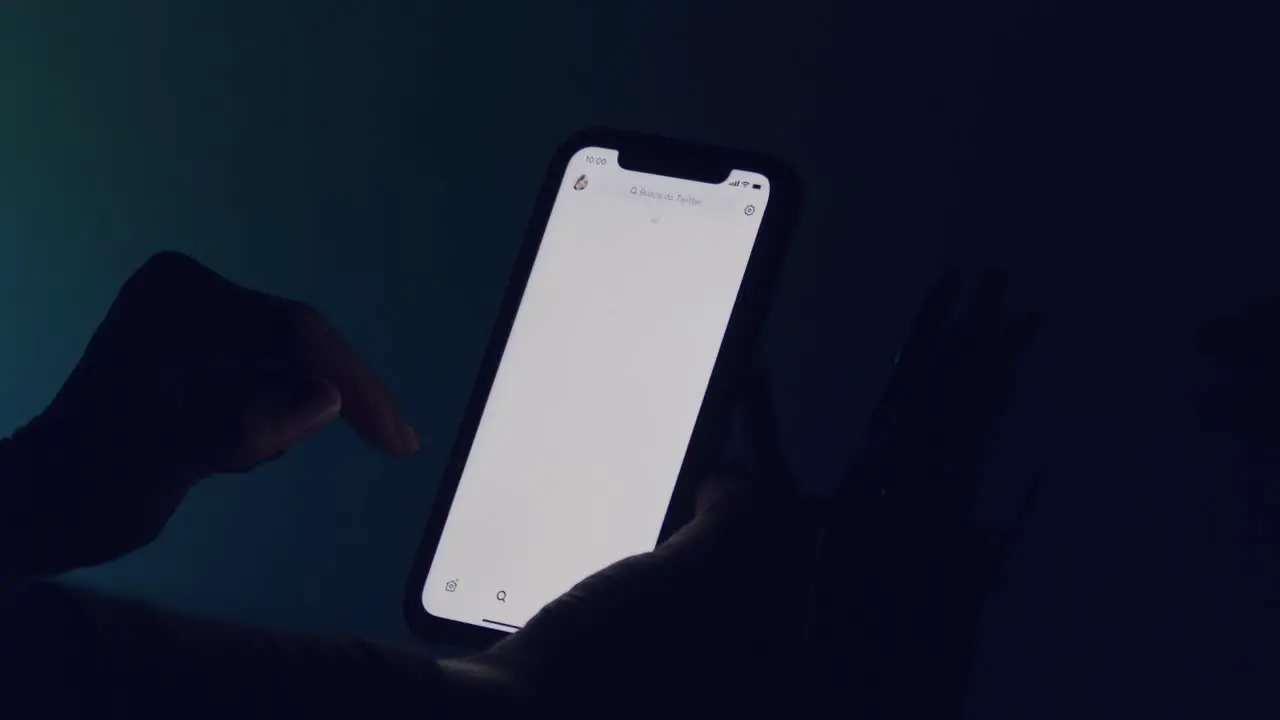 A glowing smartphone screen in the darkness reading Twitter tweets