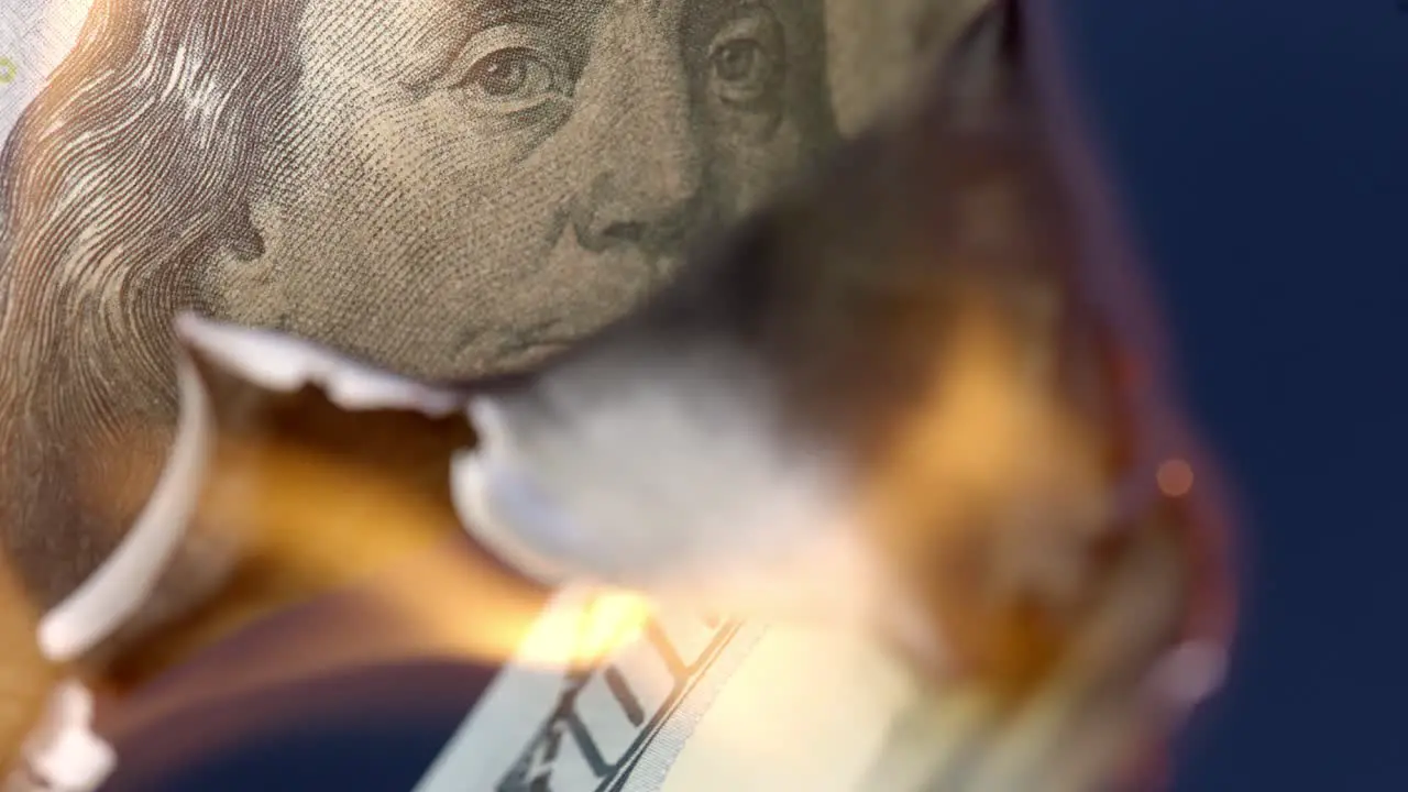 Fire burning up 100 US Dollar bill economy collapse concept