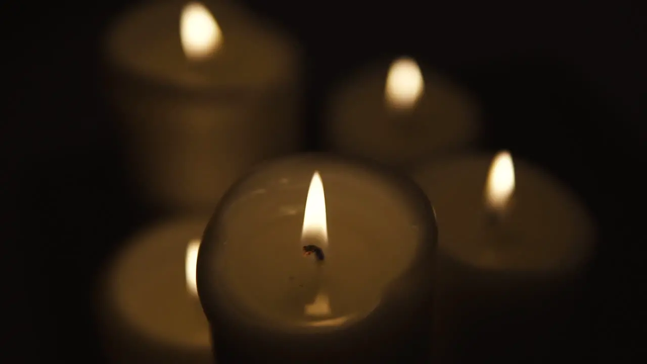 View of top Slide from right to left burning candles occupy the whole area composition on black background take focusing from blurred slow motion