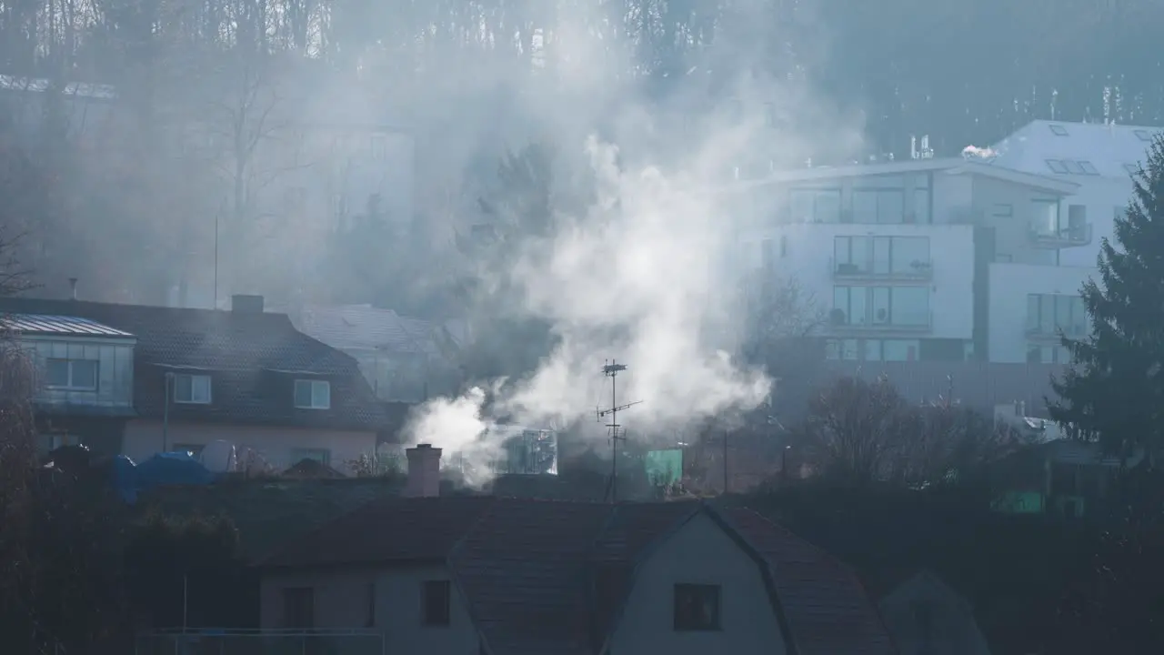 Heavy smoke rises from the chimney of the old house