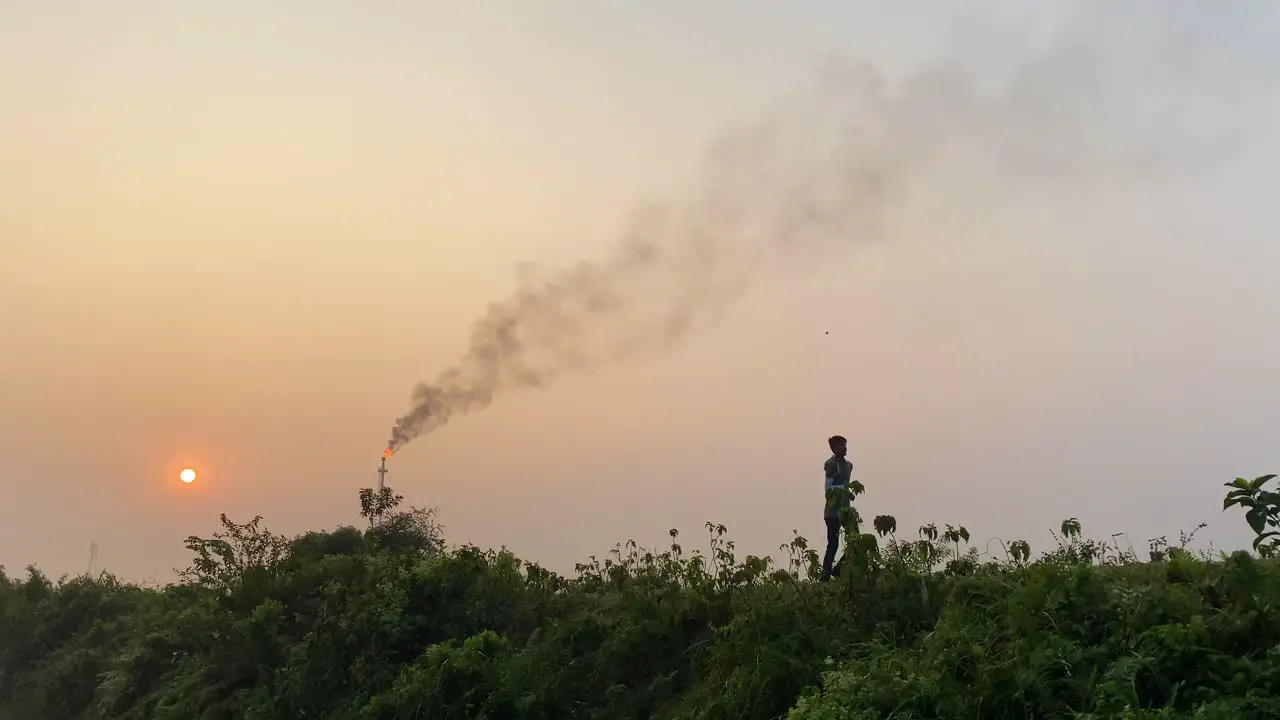 Human and pollution concept man exercising near industrial area static sunset