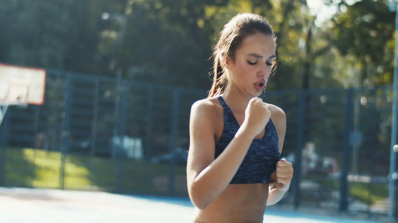 Sporty Woman Running In Place At Outdoor Court On A Summer Day