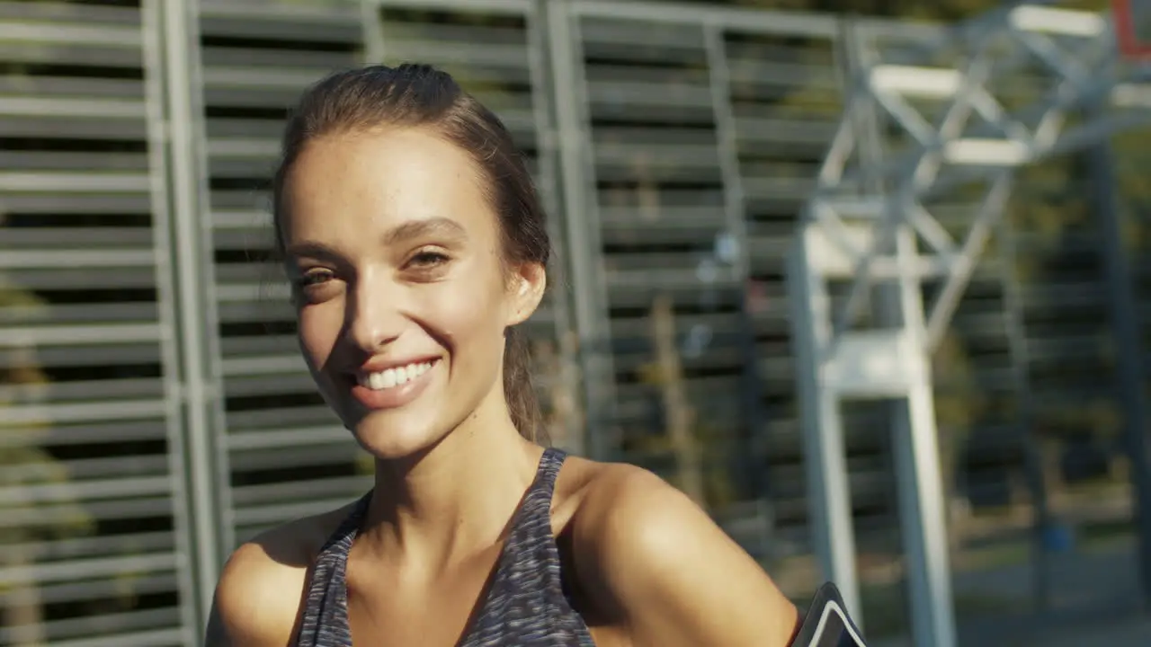 Close Up Of A Sporty Woman Smiling Cheerfully At The Camera While Standing At Sport Court On A Summer Day