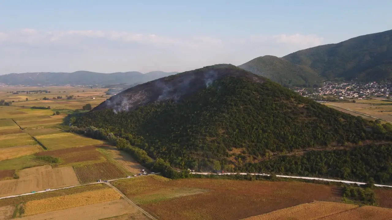 Aerial approaching burning forest over agricultural fields in Greece