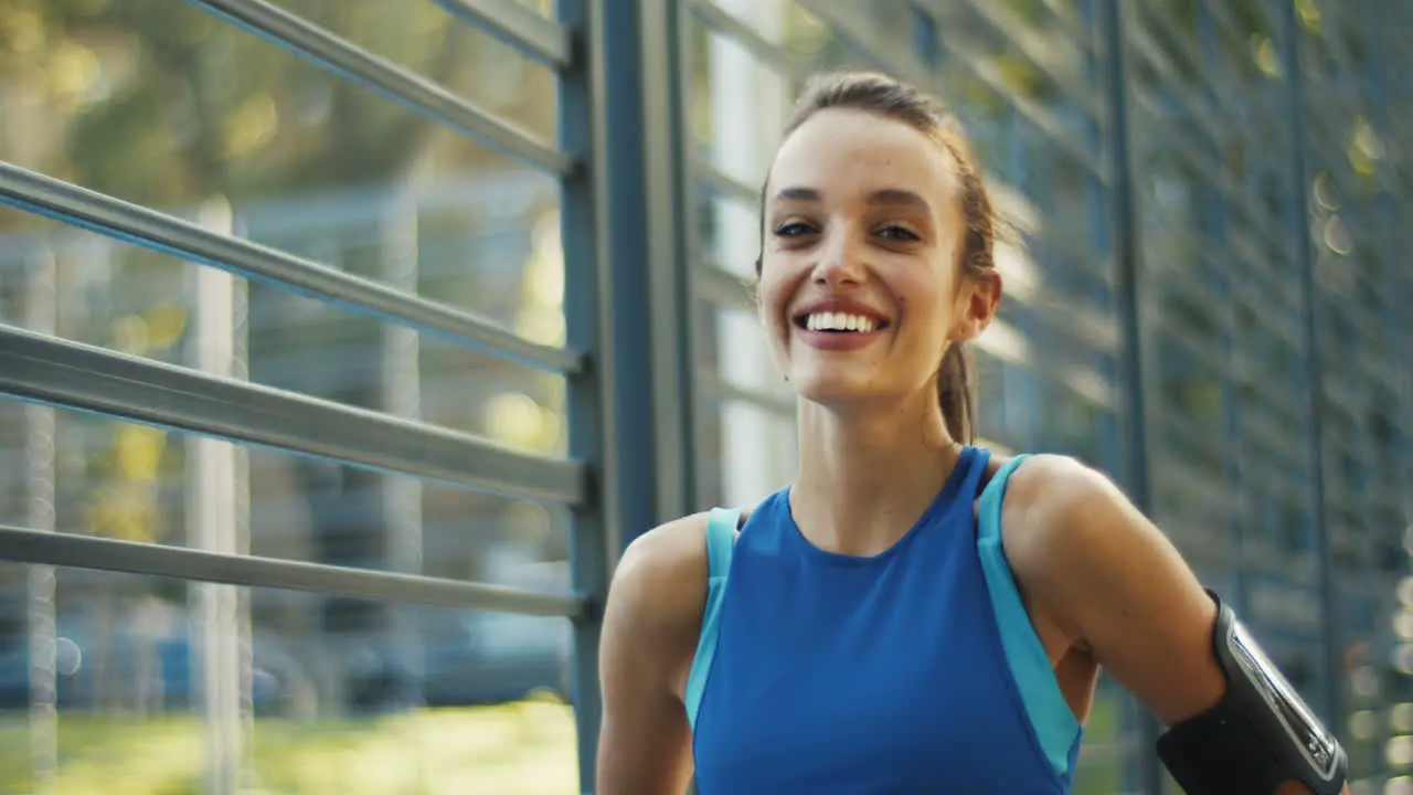 Portrait Of A Pretty Sporty Woman Looking And Smiling At The Camera While Standing At Outdoor Court On A Summer Day