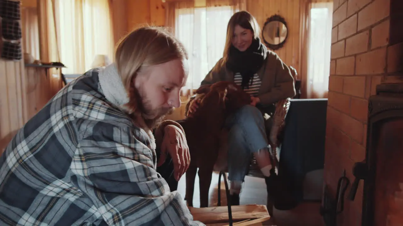 Couple with Dog Sitting by Fireplace in Farmhouse