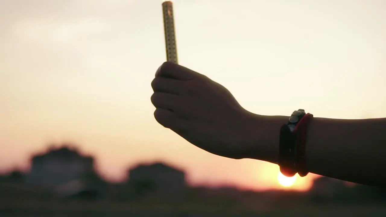 Two Friends Are Lighting Firework Candles And Celebrating Together During Sunset