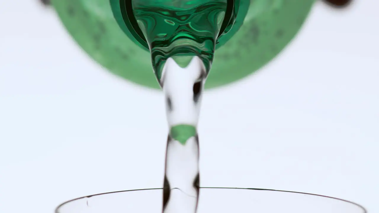 Person Filling a Glass with Liquid from a Bottle