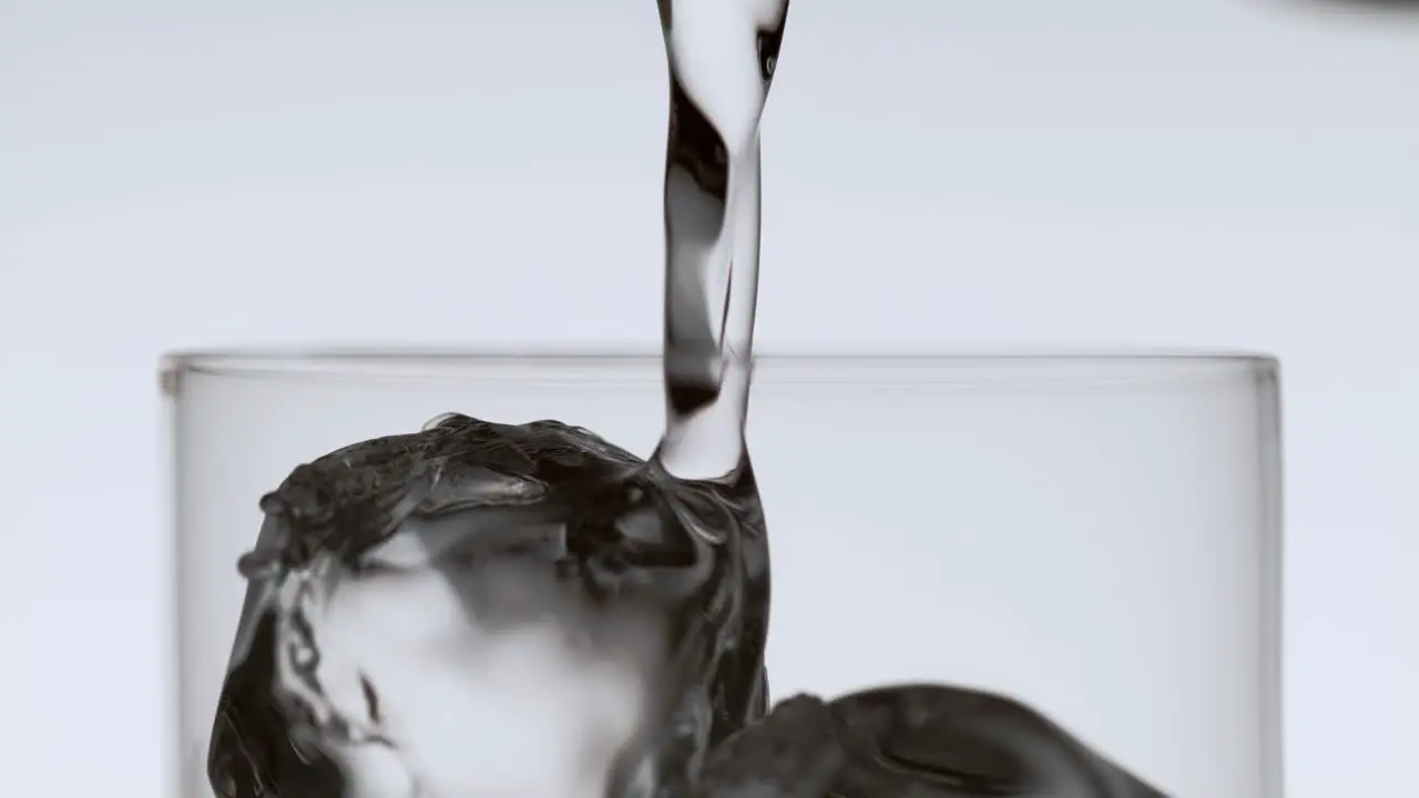 Soda Stream Flowing into a Glass with Ice Cubes