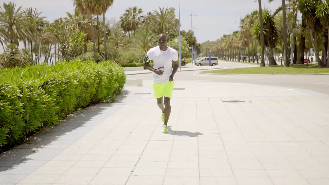 Man wearing bright yellow shorts and music device