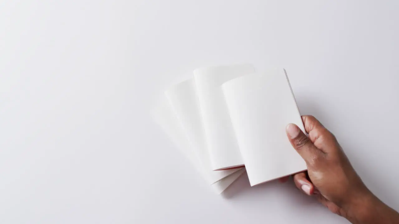 Hand laying piece of paper on pieces of paper with copy space in slow motion