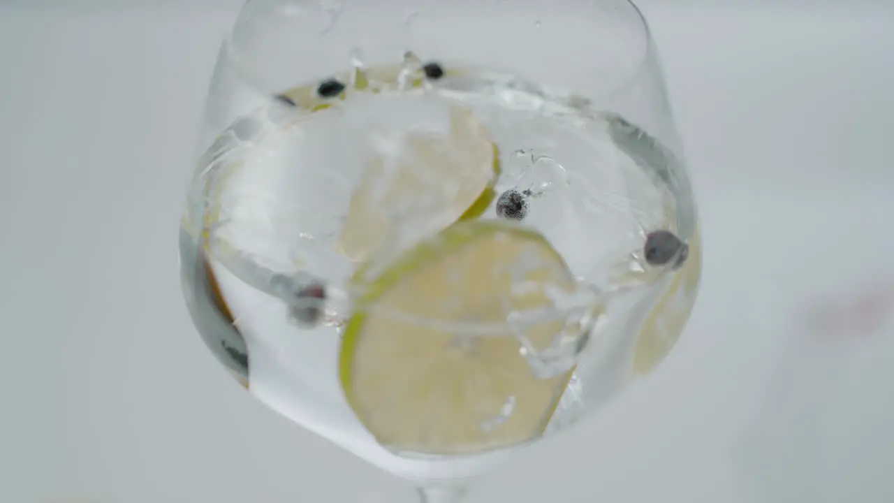 Lemon Slices Falling into a Glass with Clear Liquid