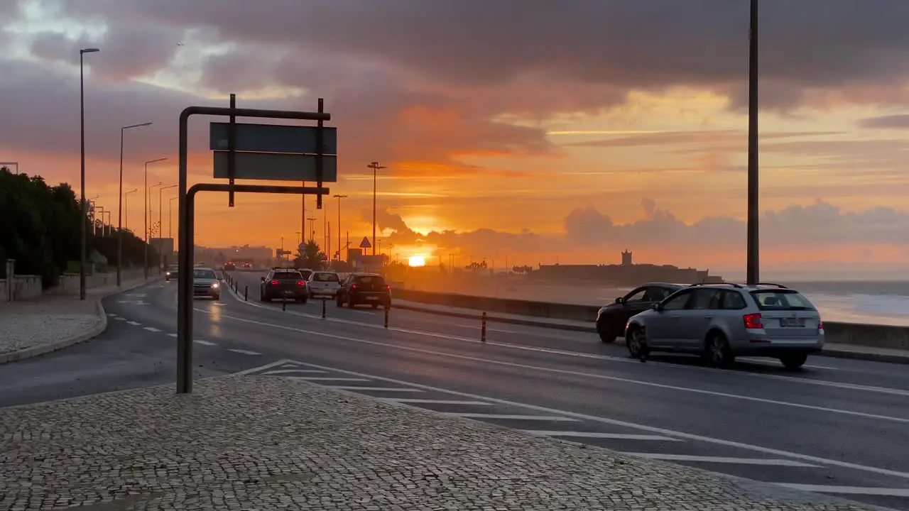 Beautiful wide view on the cars driving in the streets near Carcavelos beach in Portugal at majestic sunrise