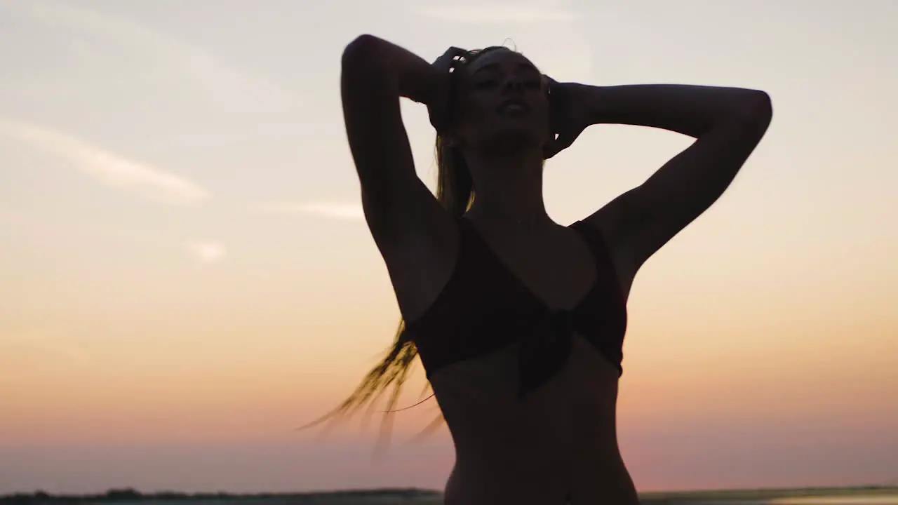 Silhouette of a girl walking on a beach during a beautiful sunset