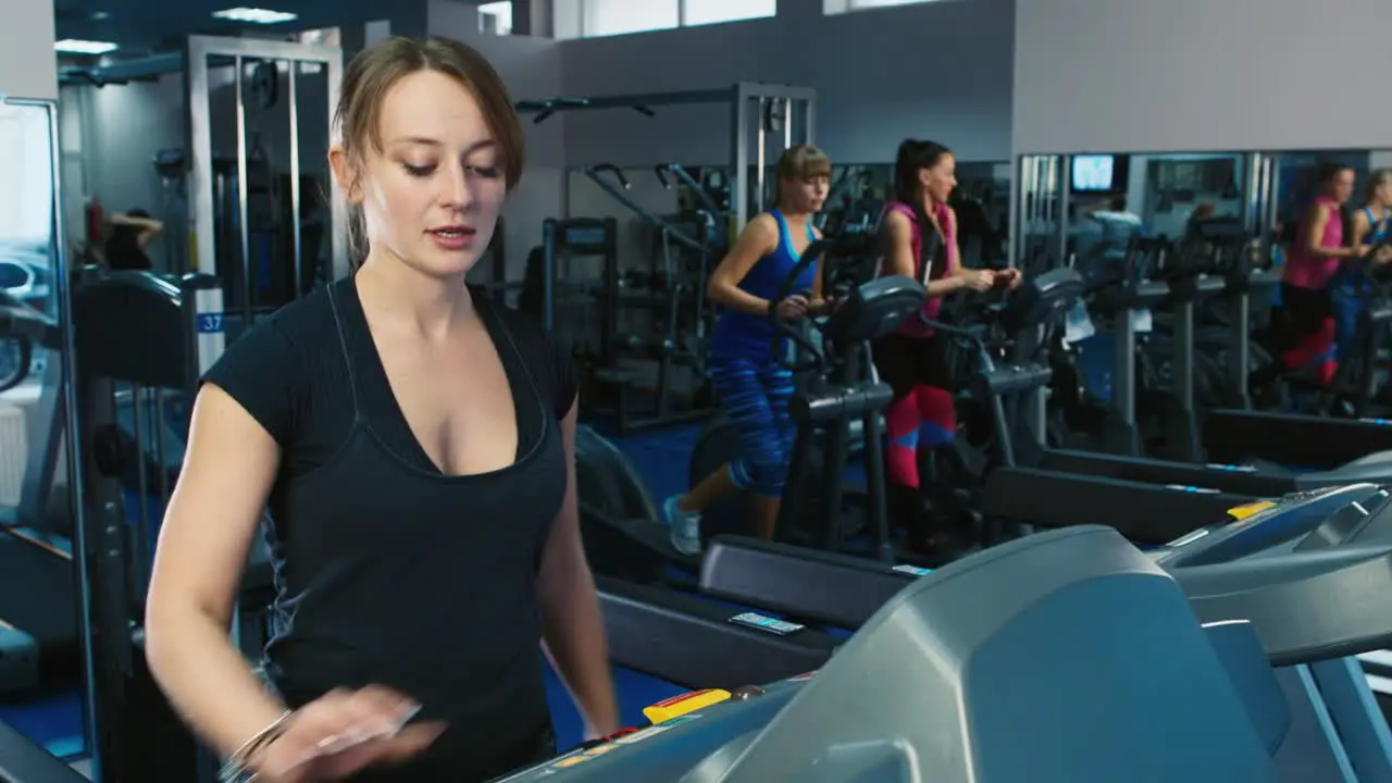 Woman trains in the gym as other people train in the background