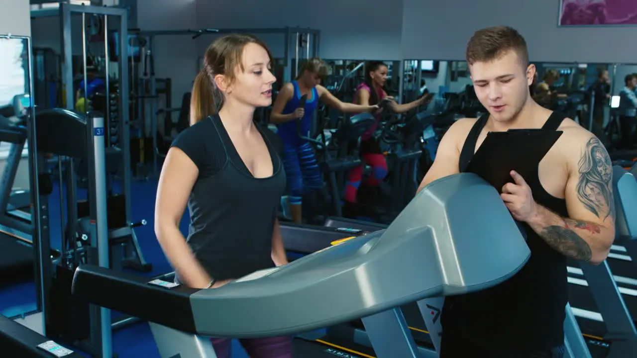 A woman trains in the gym with personal trainer