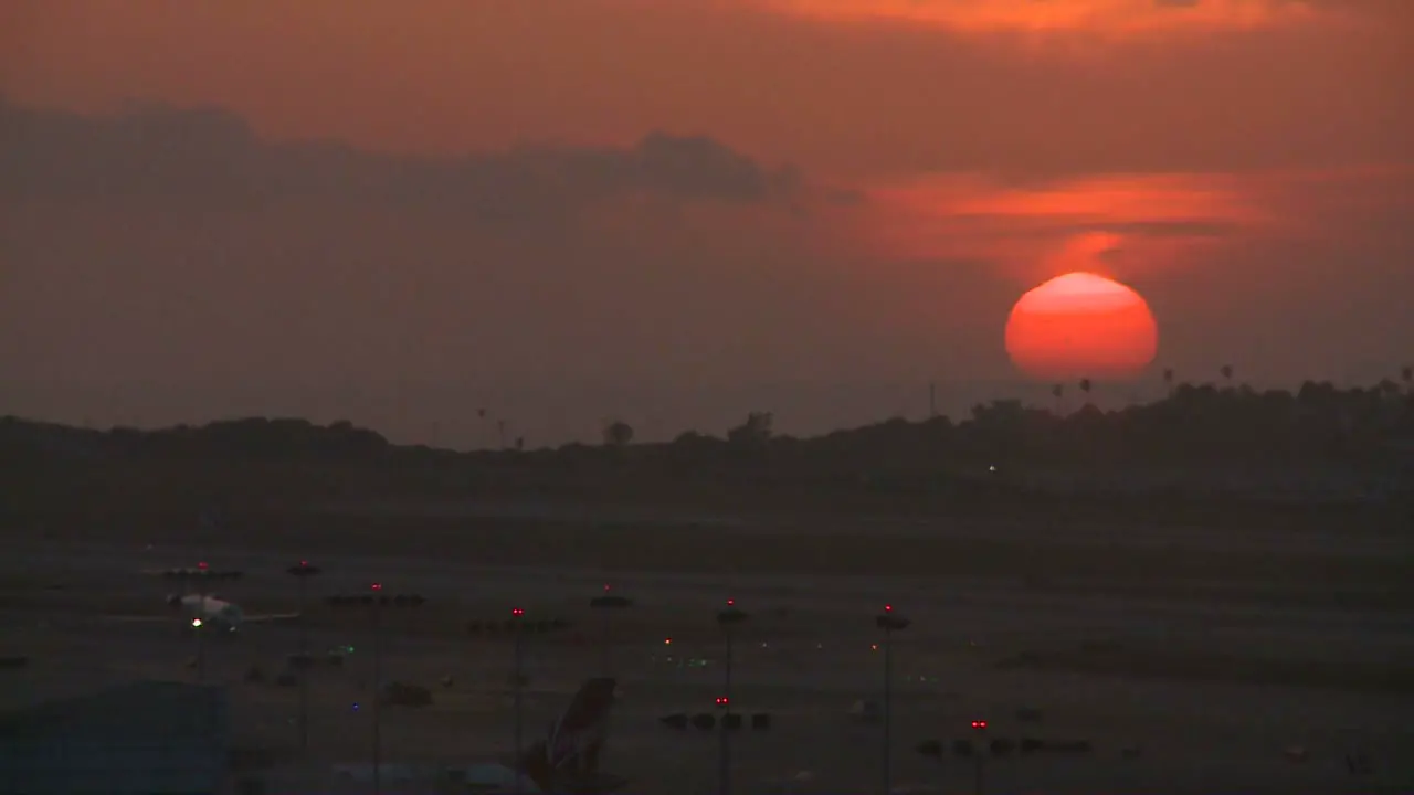 An orange ball of sun sets behind the LA hills 1