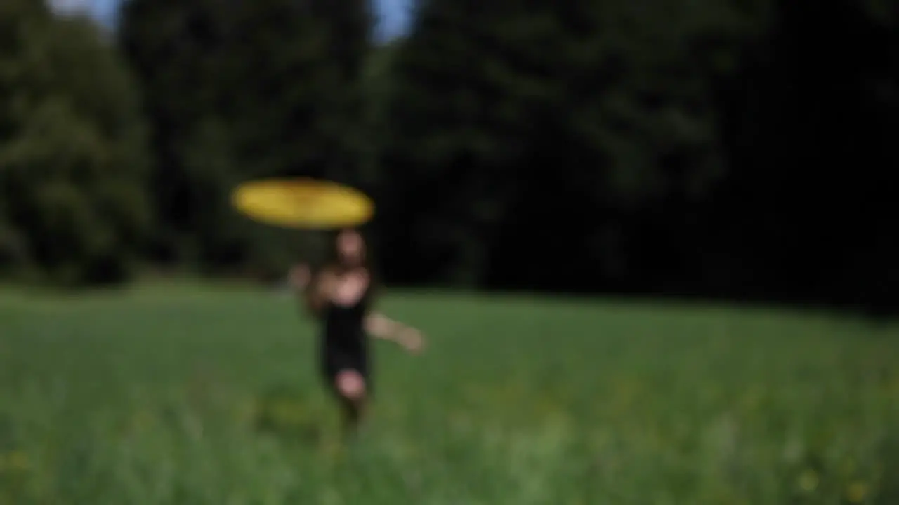 A woman with an umbrella runs through a field