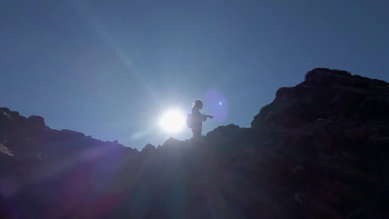 Hiker pointing to distance on top of mountain low angle Kananaskis Alberta Canada