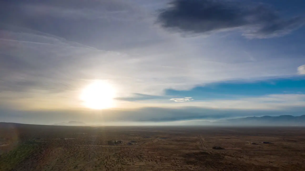 Wispy veil of clouds cross the desert as the bright sun heats up the arid landscape aerial hyper lapse