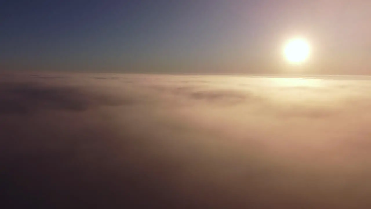 Flying over fog mist clouds and frost covered seasonal forests in sunrise light