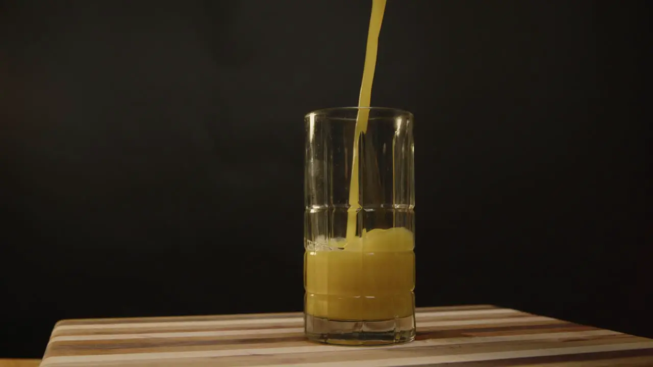 Orange juice being poured into a glass on