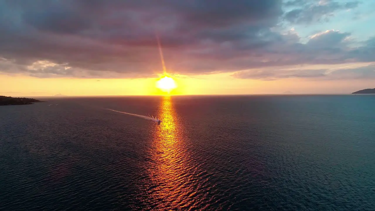 Aerial shot of a luxury speed boat coming in over the ocean at sunset