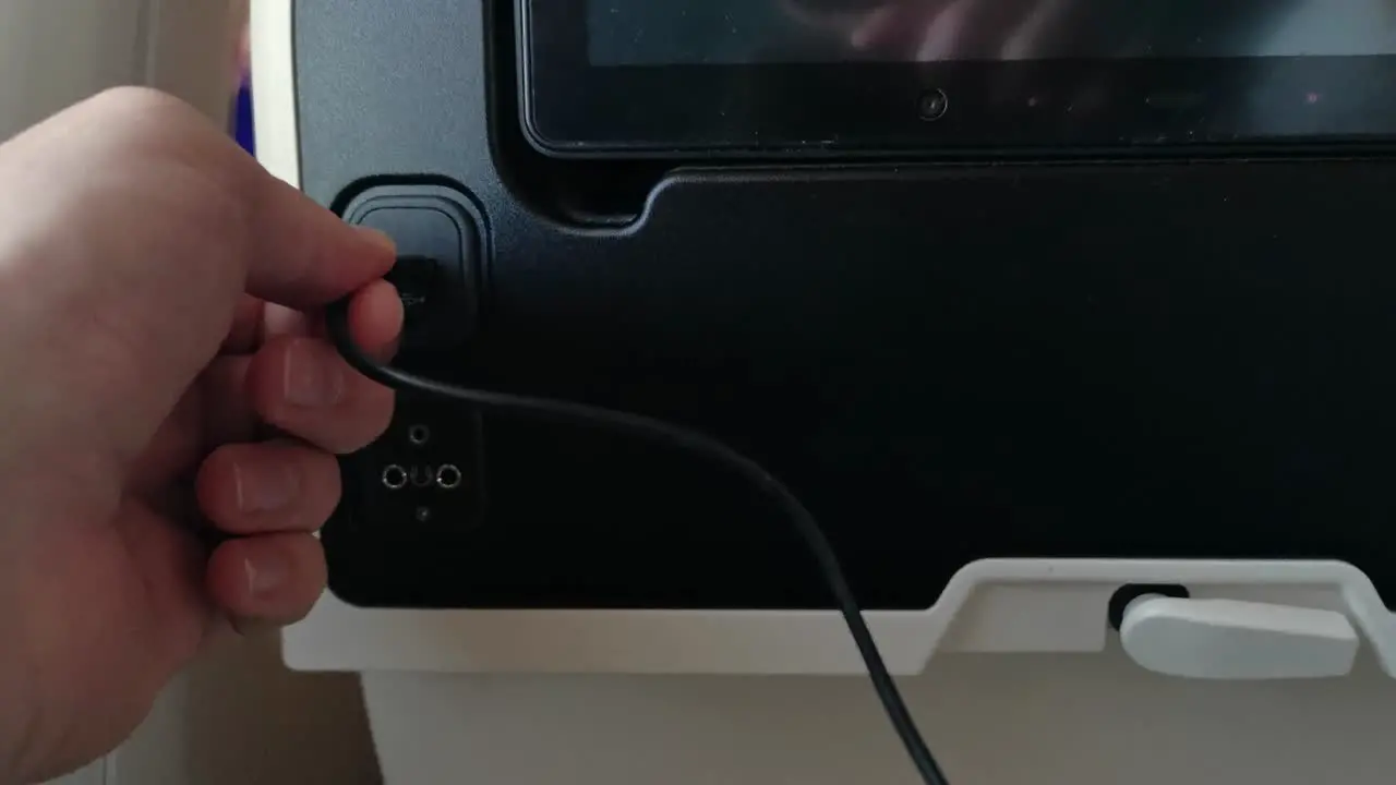 Plugging a USB device into the seat of an economy class seat