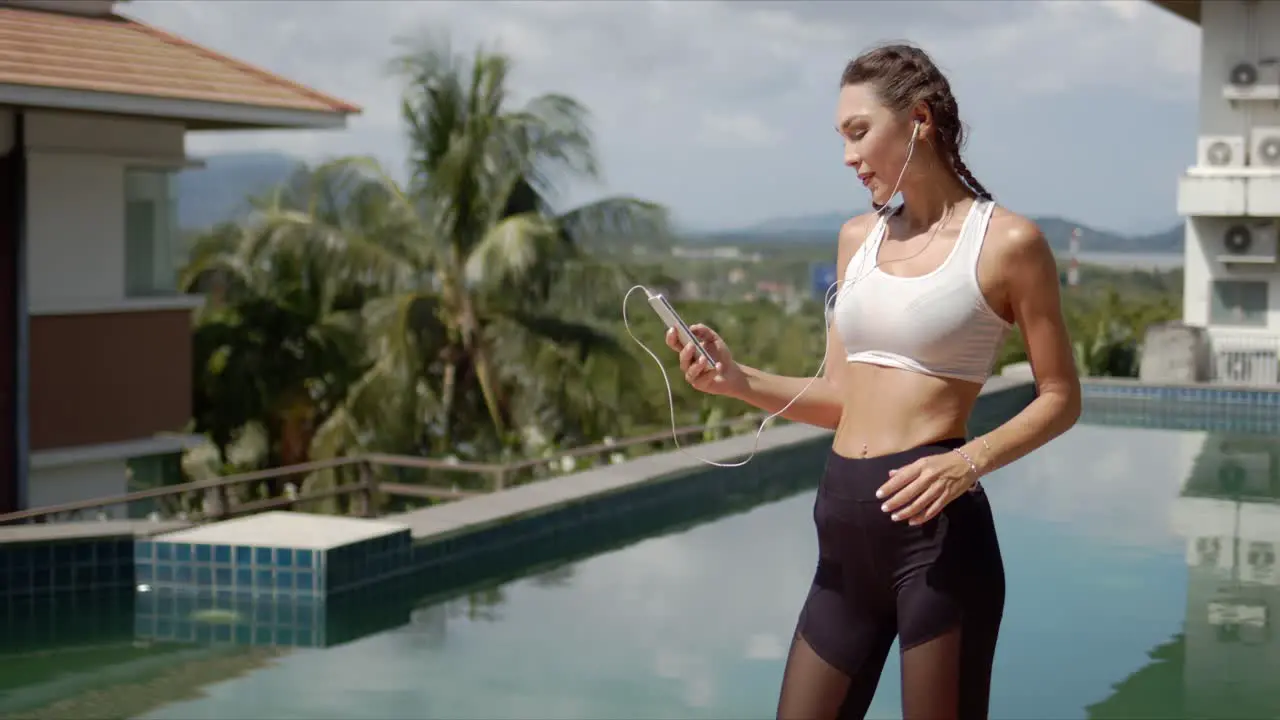 Confident athlete using smartphone on poolside