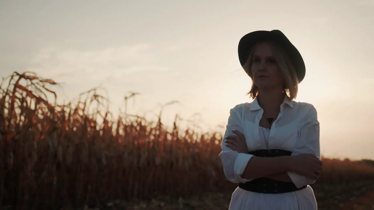 Farmer in a dress and hat walks in a field of ripe corn 7