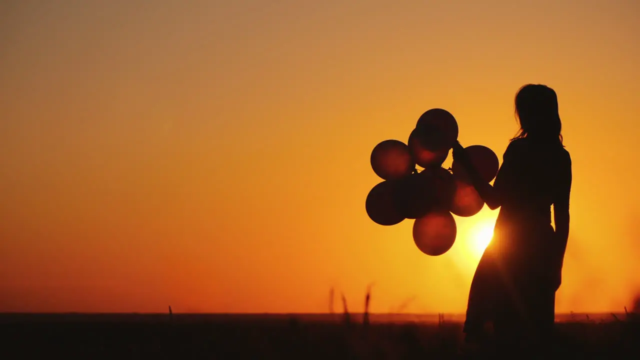 Silhouette Of A Woman With Balloons At Sunset Nostalgia Concept