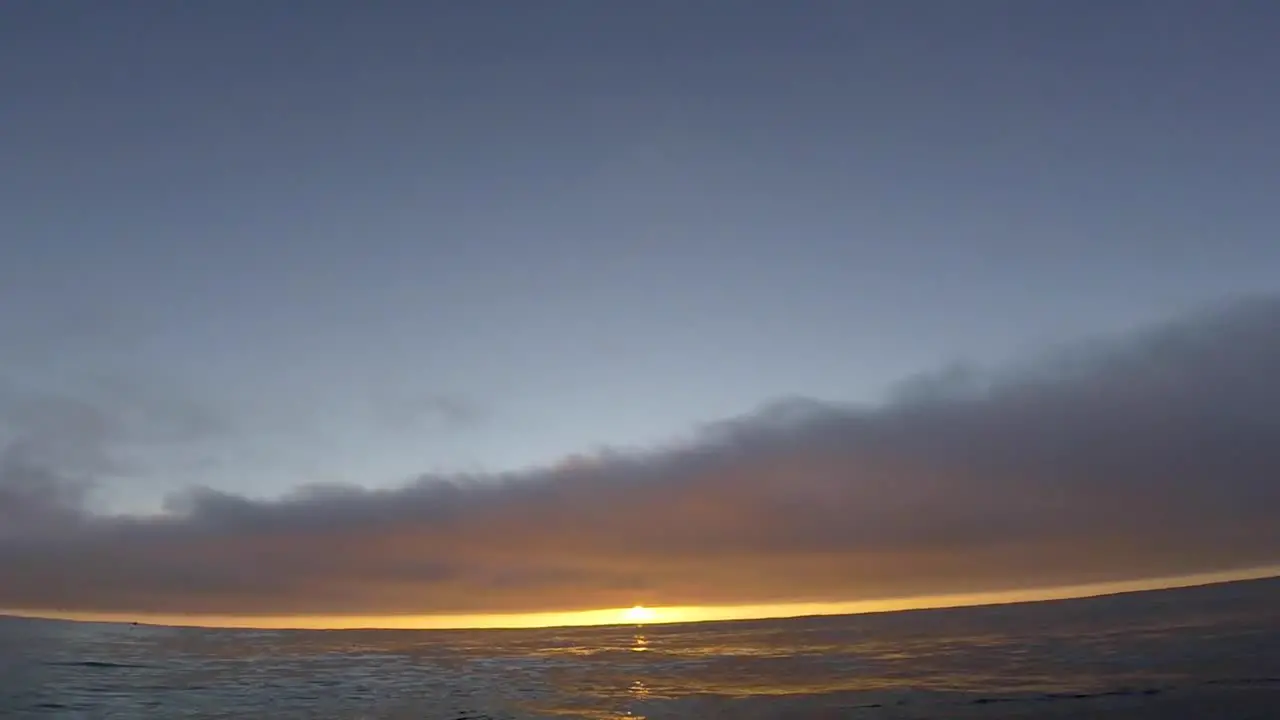 SLOW MOTION of Fantasy sunset over seamlessly looped ocean with some clouds