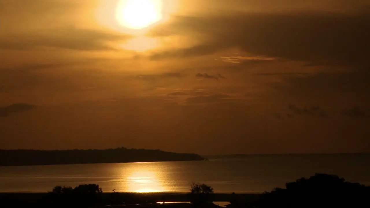 Sunset over the Rio Negro or Black River with the golden sun reflecting on the surface of the water time lapse