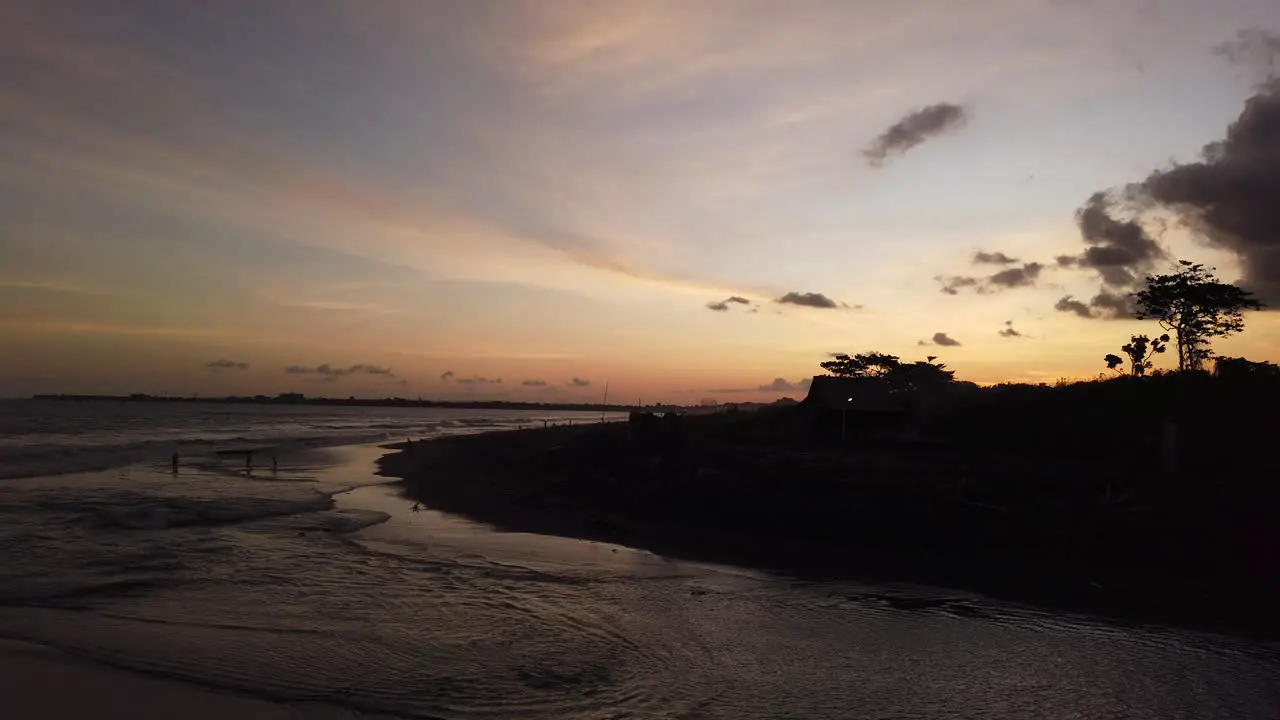 Island Silhouette at Sunset Black Sand Beach in Bali Gianyar Indonesia Ketewel Golden Hour Horizon Sky Travel and Tourism