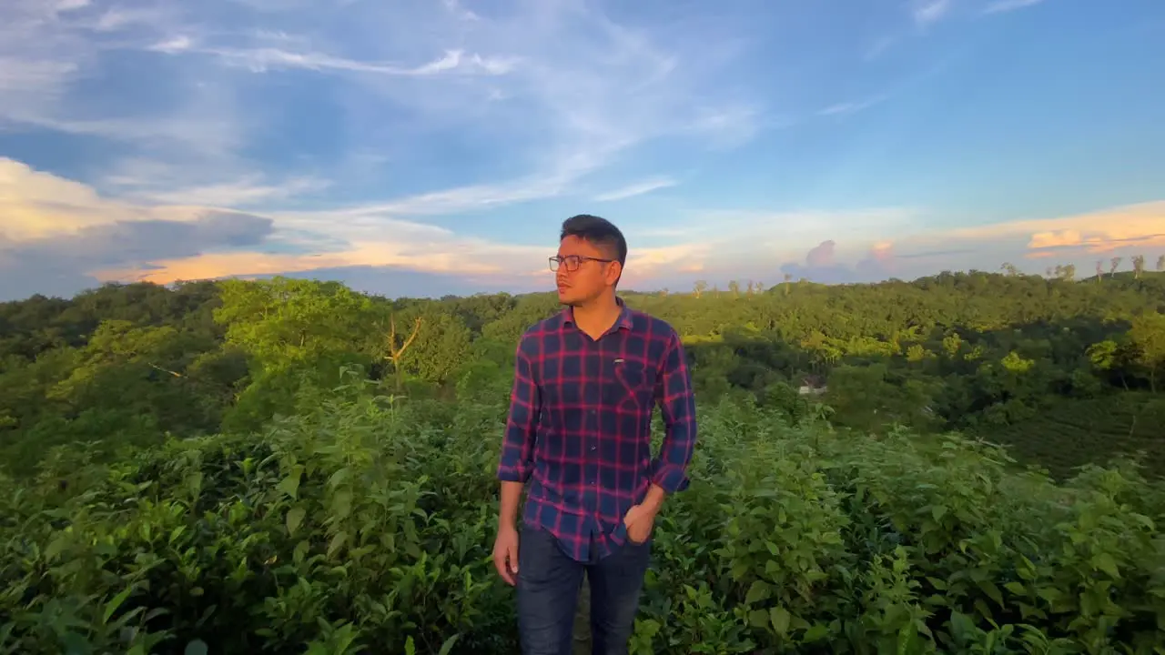 Traveler Asian man walking confidently in middle of nature Tea plantation dramatic sky